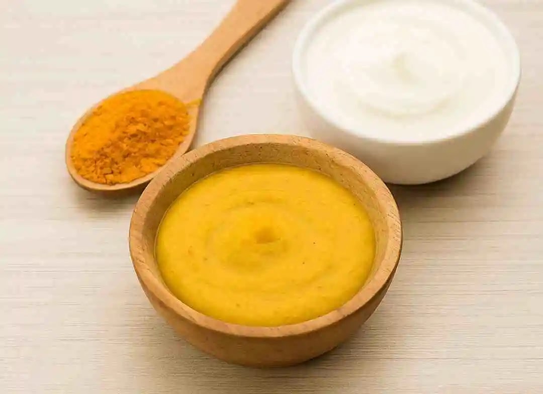 A bowl of turmeric and curd face pack with natural ingredients for glowing skin at home